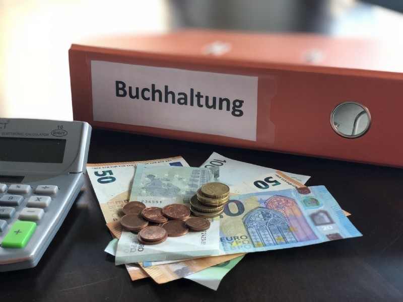 Ordner, Unterlagen & Geld als Symbol für strukturierte Buchhaltung